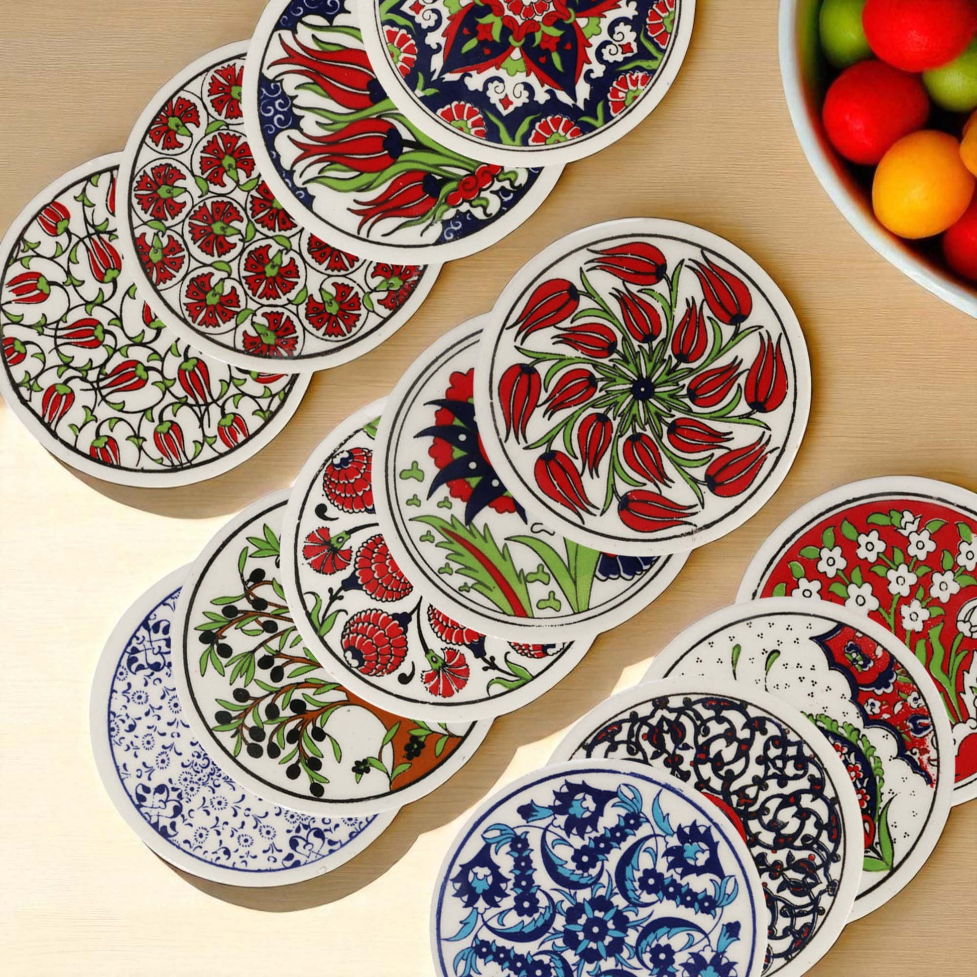 Set of colorful ceramic coasters with intricate designs on a wooden surface.