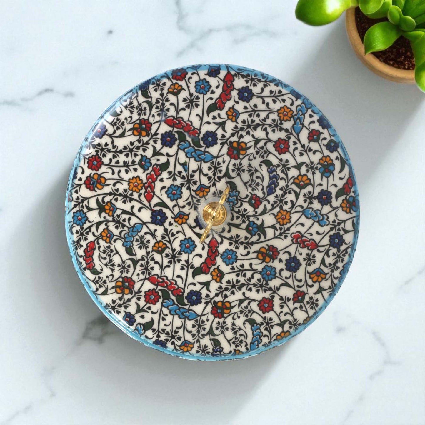 Decorative sugar bowl with floral pattern on a marble surface