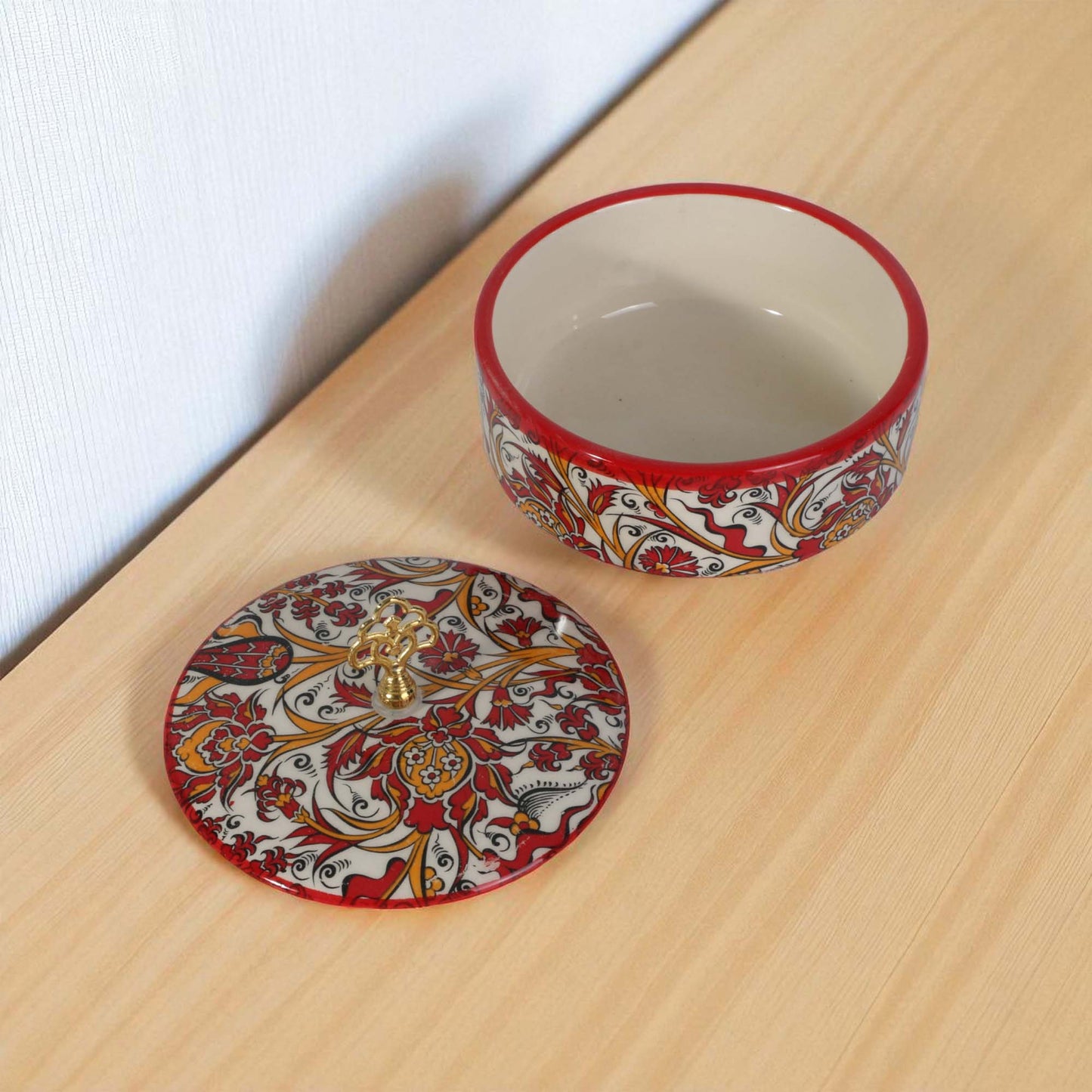 Decorative ceramic sugar bowl with intricate patterns on a wooden surface.
