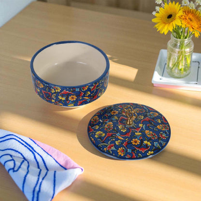 Ceramic sugar bowl with floral design on a wooden table with flowers in the background