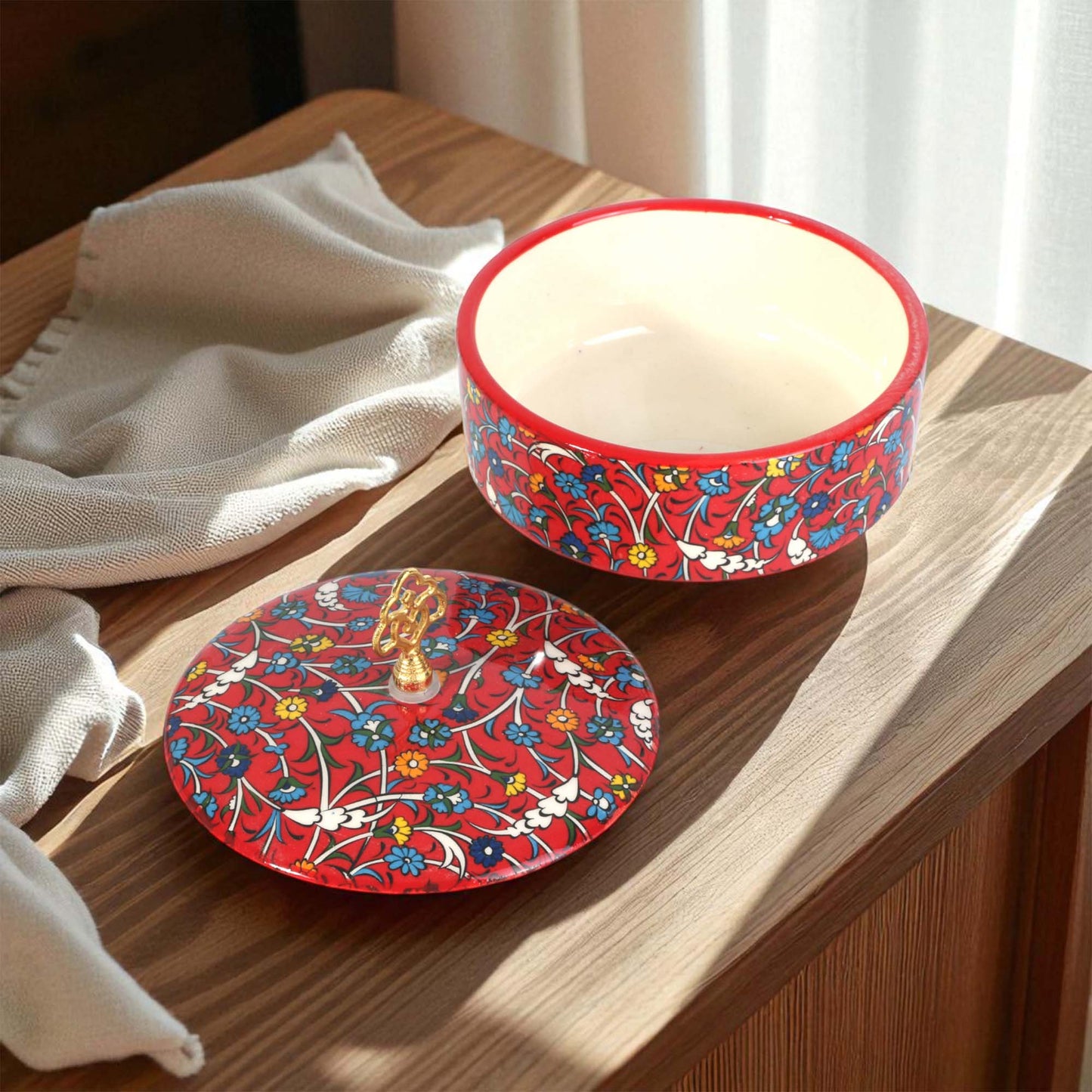 Decorative sugar bowl with floral pattern on a wooden surface