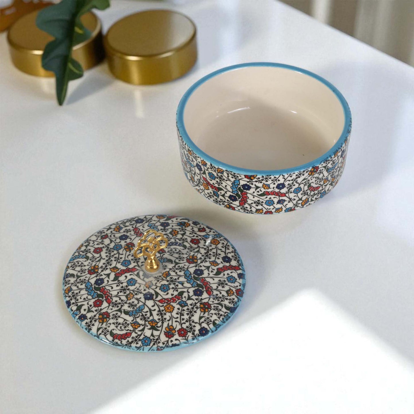 Decorative ceramic sugar bowl with lid on a white surface