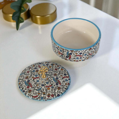 Decorative ceramic sugar bowl with lid on a white surface