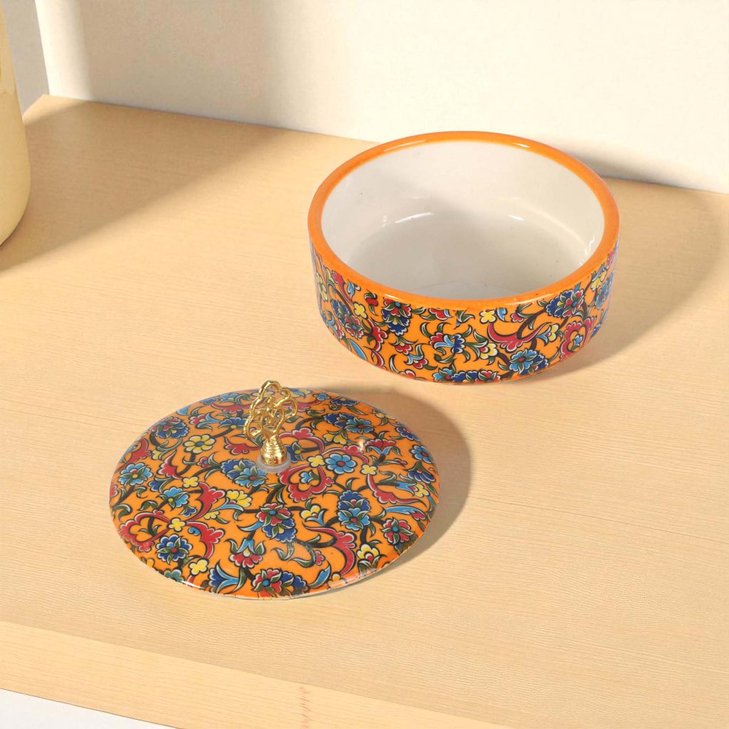 Decorative ceramic sugar bowl with colorful pattern on a wooden surface