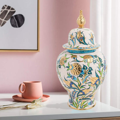 Hand-painted Golden Bloom ceramic jar with blue tulips, green leaves & gold accents. Finished with sculpted golden finial, artisan-made, perfect décor or gift.