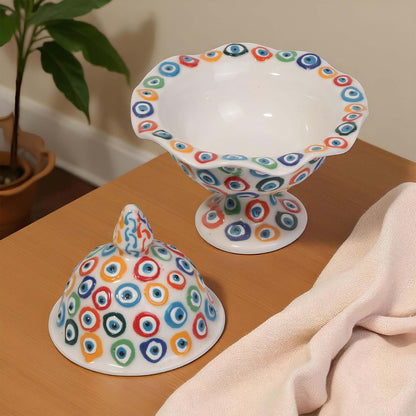 Ceramic sugar bowlwith colorful circular patterns on a wooden surface.