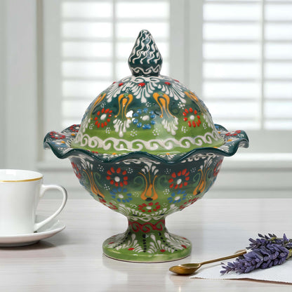 Decorative ceramic covered sugar bowl with floral patterns on a table with a cup and lavender.