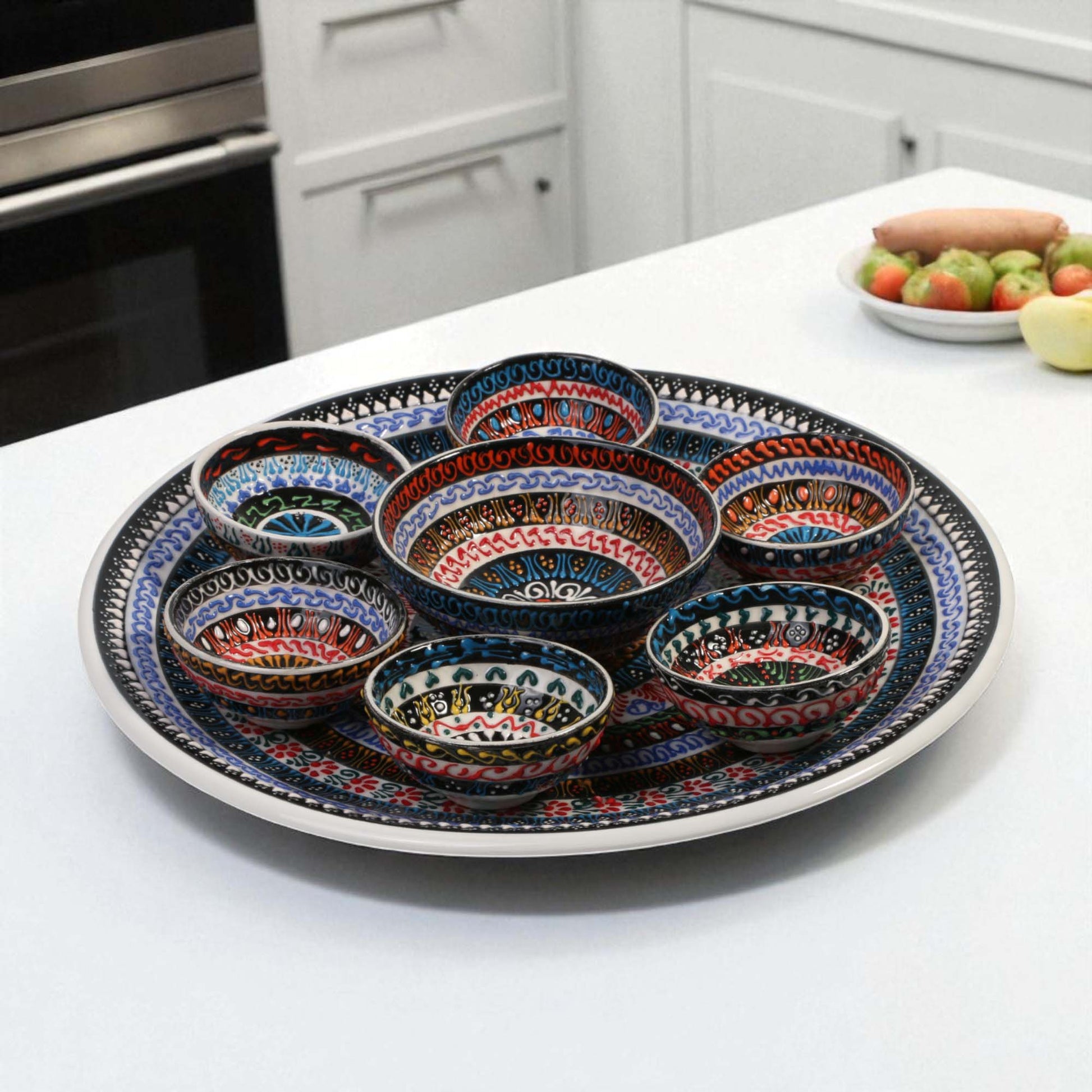 Decorative ceramic platter with colorful bowls on a kitchen counter